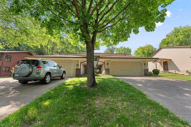 4427 Chatsworth St N, Shoreview, MN 55126 - view of front of home featuring an attached garage, asphalt driveway, brick siding, and a front yard