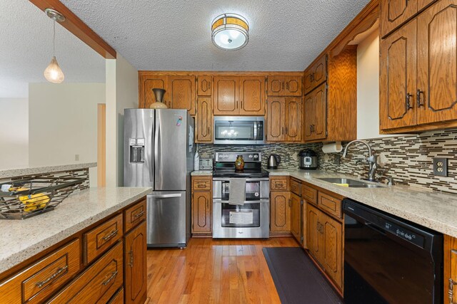4427 Chatsworth St N, Shoreview, MN 55126 - kitchen featuring stainless steel appliances, a sink, brown cabinets, and a textured ceiling