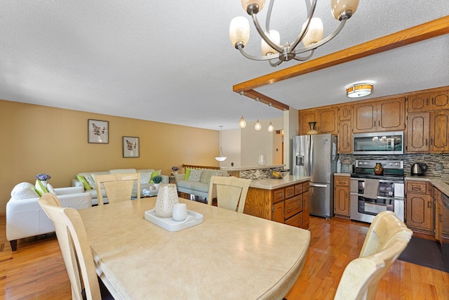 4427 Chatsworth St N, Shoreview, MN 55126 - dining area with a chandelier, light wood-style flooring, and a textured ceiling