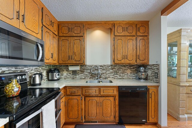 4427 Chatsworth St N, Shoreview, MN 55126 - kitchen featuring stainless steel appliances, a sink, a textured ceiling, brown cabinets, and light countertops
