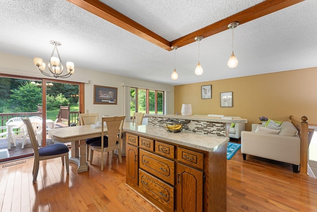 4427 Chatsworth St N, Shoreview, MN 55126 - kitchen featuring a textured ceiling, brown cabinetry, light wood-style floors, pendant lighting, and a chandelier
