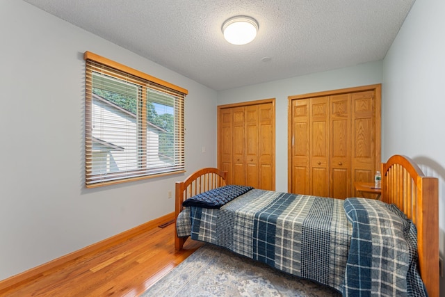 4427 Chatsworth St N, Shoreview, MN 55126 - bedroom with two closets, wood finished floors, a textured ceiling, and baseboards