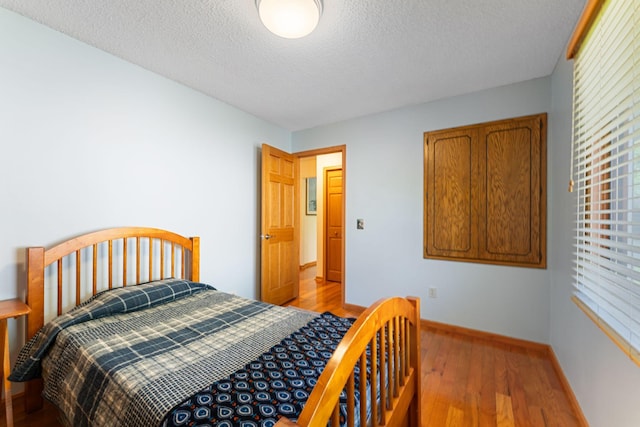 4427 Chatsworth St N, Shoreview, MN 55126 - bedroom with a textured ceiling, baseboards, and light wood-type flooring