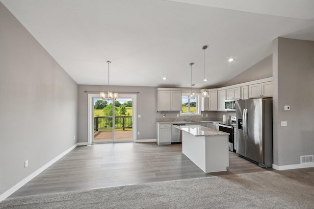 1019 188th St, Garfield Twp, WI 54009 - kitchen featuring appliances with stainless steel finishes, a chandelier, a kitchen island, lofted ceiling, and plenty of natural light