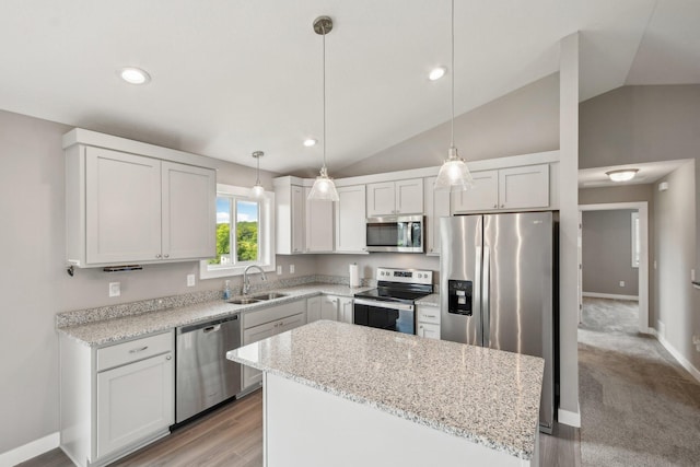1019 188th St, Garfield Twp, WI 54009 - kitchen featuring appliances with stainless steel finishes, lofted ceiling, a center island, light stone counters, and decorative light fixtures