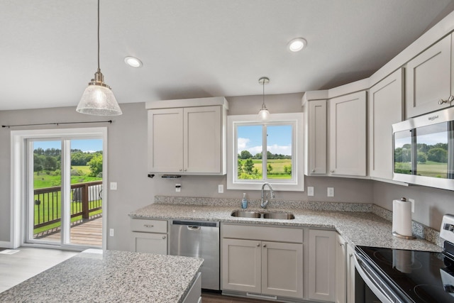 1019 188th St, Garfield Twp, WI 54009 - kitchen featuring appliances with stainless steel finishes, recessed lighting, decorative light fixtures, light stone counters, and light wood-type flooring