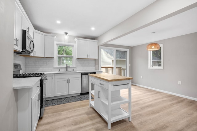 5814 Ewing Ave N, Brooklyn Center, MN 55429 - kitchen featuring stainless steel appliances, tasteful backsplash, wood counters, white cabinetry, and light wood-type flooring