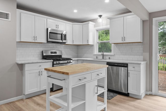 5814 Ewing Ave N, Brooklyn Center, MN 55429 - kitchen with appliances with stainless steel finishes, butcher block counters, light wood finished floors, plenty of natural light, and recessed lighting