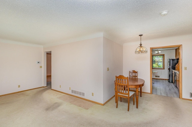 2165 Ross Ave E, Saint Paul, MN 55119 - carpeted dining room featuring a chandelier, a textured ceiling, and baseboards
