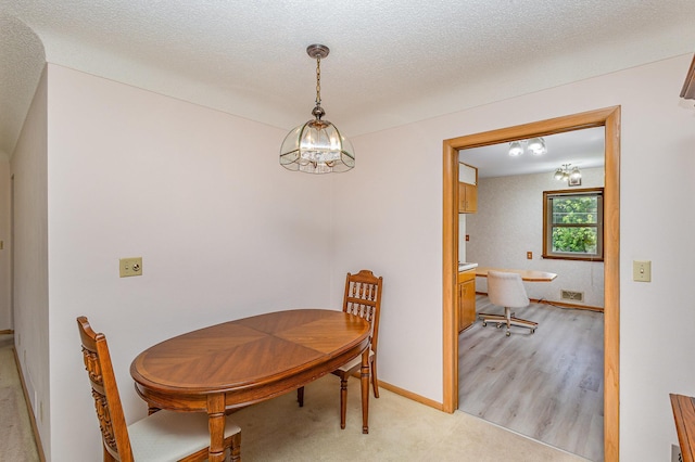 2165 Ross Ave E, Saint Paul, MN 55119 - dining area featuring a chandelier, baseboards, and light wood-style flooring