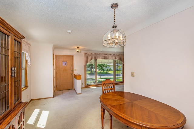 2165 Ross Ave E, Saint Paul, MN 55119 - dining space with a chandelier, light carpet, a textured ceiling, and baseboards