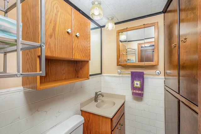 2165 Ross Ave E, Saint Paul, MN 55119 - half bathroom with toilet, vanity, wainscoting, and tile walls