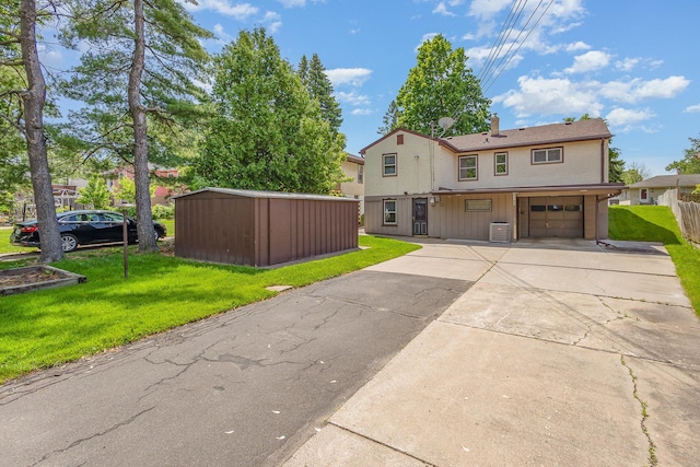 2165 Ross Ave E, Saint Paul, MN 55119 - view of front of home featuring a garage, a front lawn, concrete driveway, a chimney, and a shed