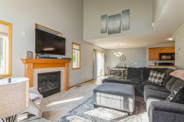 14754 Peridot St NW, Ramsey, MN 55303 - living room featuring a tiled fireplace, light colored carpet, baseboards, and a chandelier