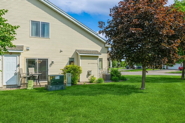 14754 Peridot St NW, Ramsey, MN 55303 - rear view of property featuring a lawn, central AC unit, and roof with shingles