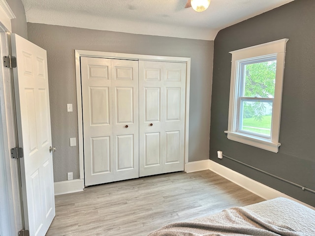 803 Jefferson Ave, Albert Lea, MN 56007 - unfurnished bedroom with light wood-style flooring, a closet, and baseboards
