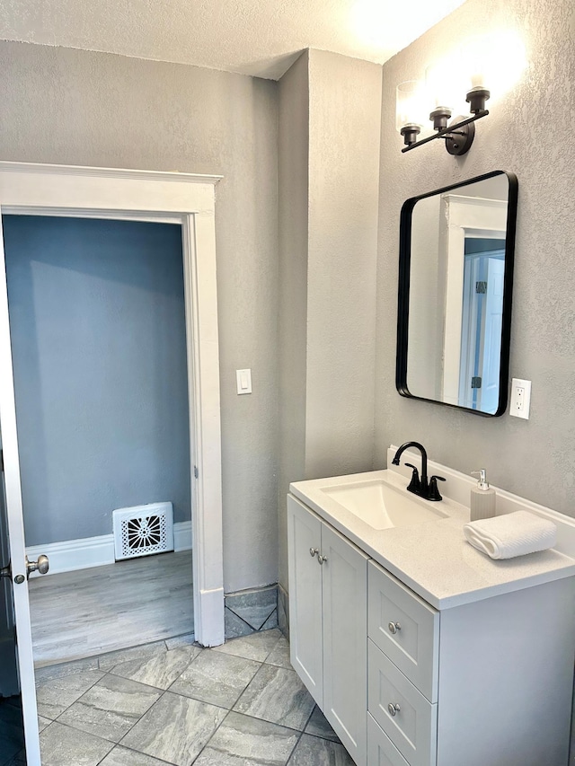 803 Jefferson Ave, Albert Lea, MN 56007 - bathroom featuring vanity, a textured wall, and baseboards
