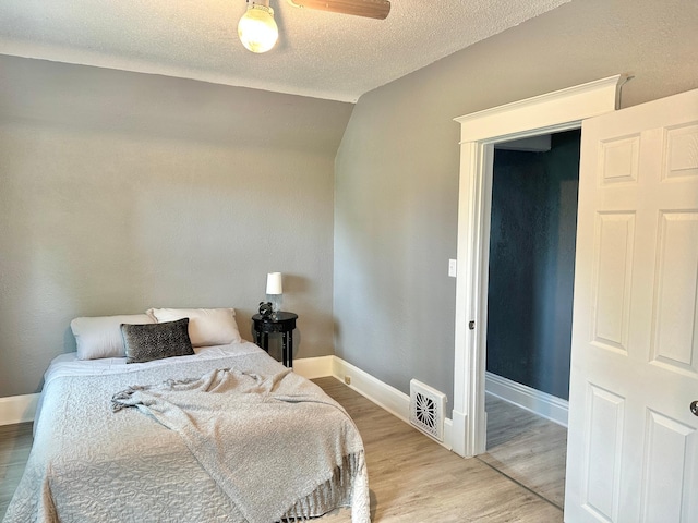 803 Jefferson Ave, Albert Lea, MN 56007 - bedroom with wood finished floors, lofted ceiling, and a textured ceiling