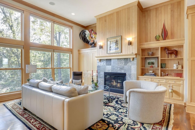 10025 Adam Ave, Inver Grove Heights, MN 55077 - living room with a tiled fireplace, light wood finished floors, and ornamental molding