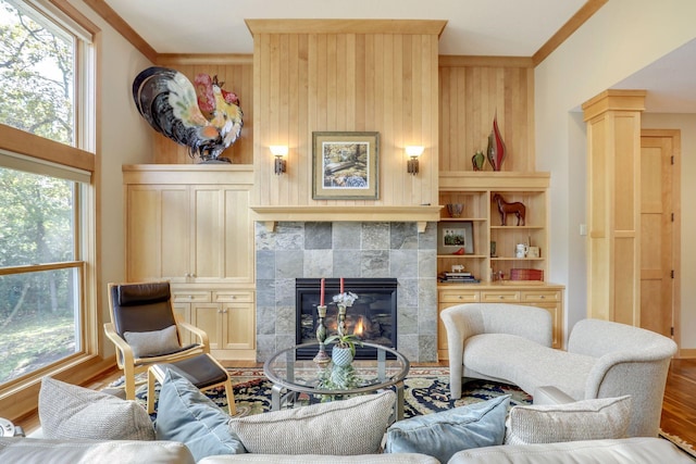 10025 Adam Ave, Inver Grove Heights, MN 55077 - living area featuring crown molding, a tile fireplace, wood finished floors, healthy amount of natural light, and wooden walls