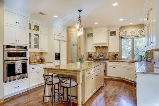 10025 Adam Ave, Inver Grove Heights, MN 55077 - kitchen with double oven, backsplash, dark wood finished floors, light stone counters, and recessed lighting