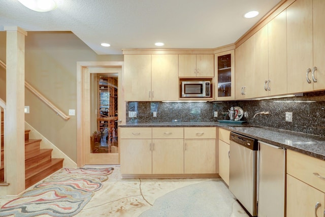 10025 Adam Ave, Inver Grove Heights, MN 55077 - kitchen with appliances with stainless steel finishes, light brown cabinets, dark stone countertops, decorative backsplash, and glass insert cabinets