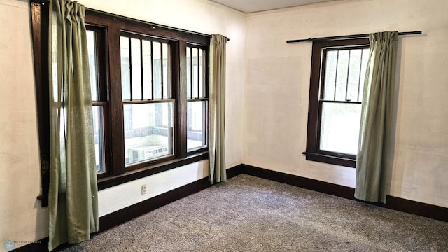 1602 11th St N, Fargo, ND 58102 - spare room featuring dark colored carpet, crown molding, and baseboards