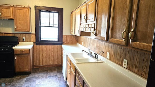 1602 11th St N, Fargo, ND 58102 - kitchen featuring black range with gas stovetop, a sink, wainscoting, wooden walls, and light countertops