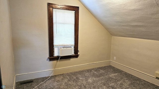1602 11th St N, Fargo, ND 58102 - additional living space featuring cooling unit, lofted ceiling, carpet flooring, a textured ceiling, and baseboards