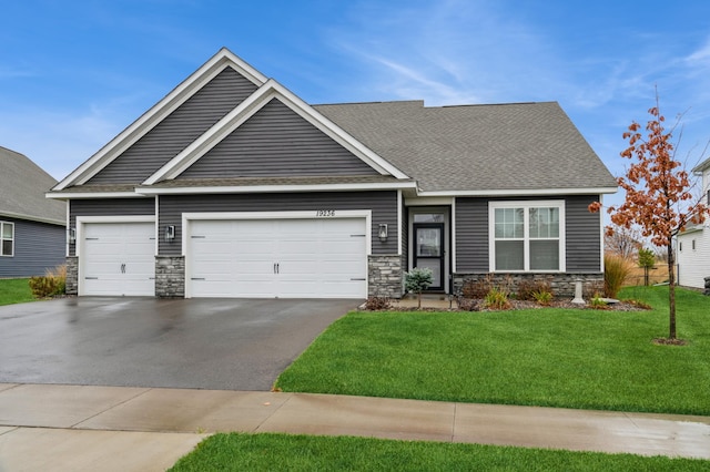 19236 Grass Lake Trl, Rogers, MN 55374 - view of front of house with stone siding, asphalt driveway, a garage, and a front yard