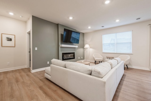 19236 Grass Lake Trl, Rogers, MN 55374 - living room featuring light wood finished floors, baseboards, a glass covered fireplace, and recessed lighting