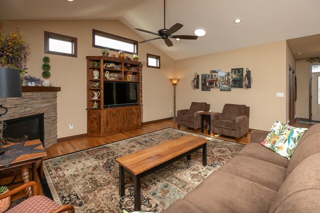 2238 Marvs Ln NE, Stewartville, MN 55976 - living area featuring ceiling fan, wood finished floors, a stone fireplace, baseboards, and high vaulted ceiling