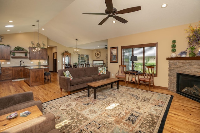 2238 Marvs Ln NE, Stewartville, MN 55976 - living area featuring lofted ceiling, a chandelier, light wood finished floors, ceiling fan, and a fireplace