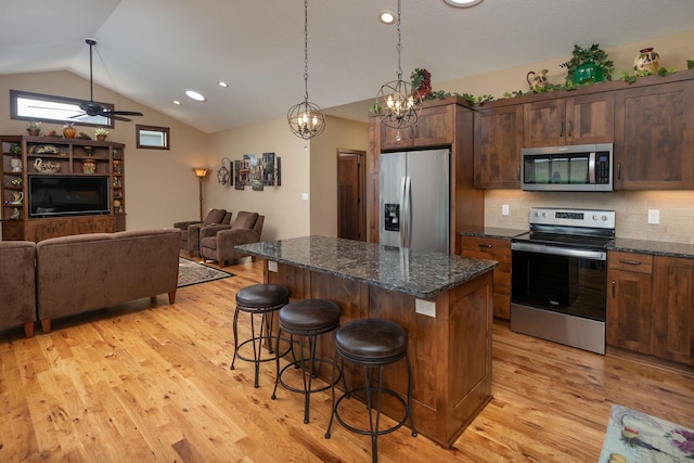 2238 Marvs Ln NE, Stewartville, MN 55976 - kitchen with stainless steel appliances, vaulted ceiling, a kitchen island, a kitchen bar, and light wood-style floors