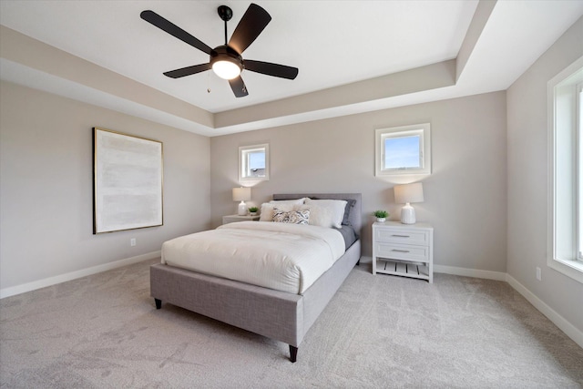 4980 Kyla Way SE, Prior Lake, MN 55372 - carpeted bedroom featuring multiple windows, ceiling fan, and a tray ceiling