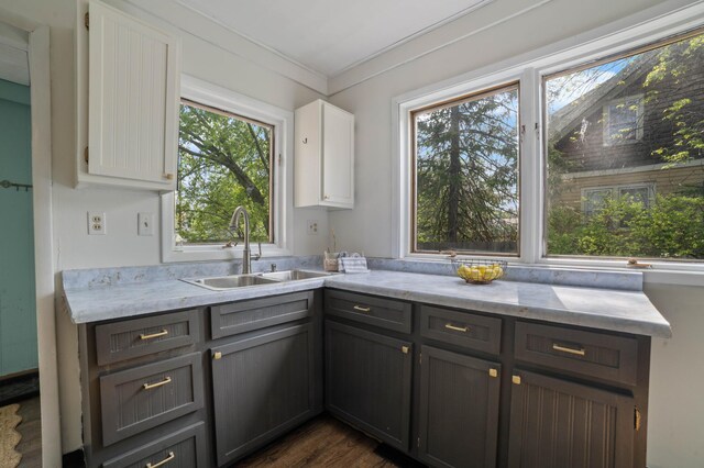 5232 Tioga St, Duluth, MN 55804 - kitchen with a sink, white cabinets, dark wood-style floors, gray cabinets, and crown molding