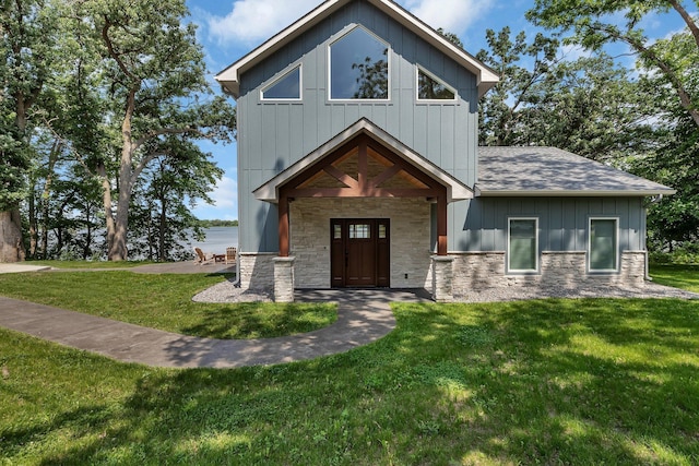 565 Brooks Lake Rd NW, Cokato, MN 55321 - view of front of property featuring stone siding, a front yard, roof with shingles, board and batten siding, and a water view
