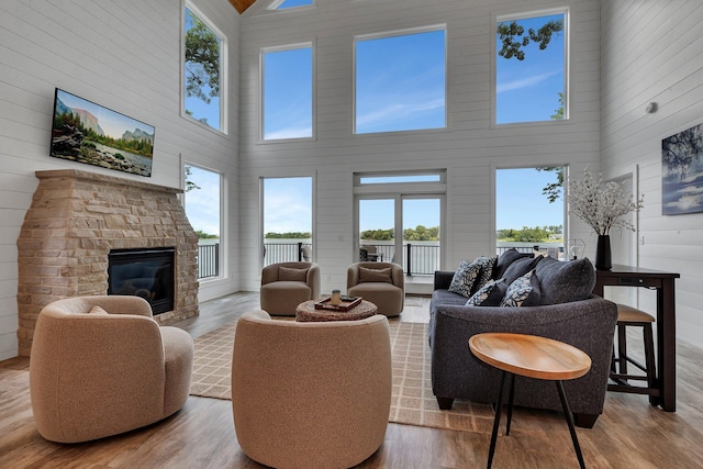 565 Brooks Lake Rd NW, Cokato, MN 55321 - living room featuring a towering ceiling, wood finished floors, a fireplace, healthy amount of natural light, and wooden walls