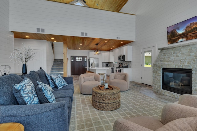 565 Brooks Lake Rd NW, Cokato, MN 55321 - living room featuring wood ceiling, stairs, healthy amount of natural light, a fireplace, and wood walls