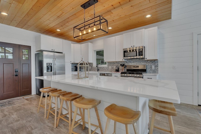 565 Brooks Lake Rd NW, Cokato, MN 55321 - kitchen featuring appliances with stainless steel finishes, wooden ceiling, white cabinetry, backsplash, and decorative light fixtures