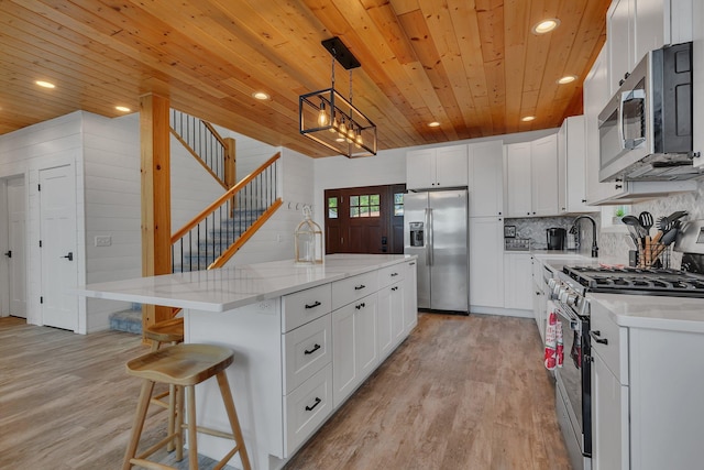 565 Brooks Lake Rd NW, Cokato, MN 55321 - kitchen with appliances with stainless steel finishes, wooden ceiling, recessed lighting, light wood finished floors, and a center island