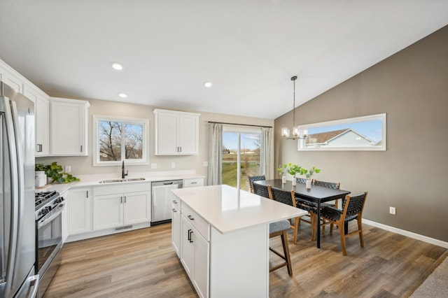 129 Terning Way, Howard Lake, MN 55349 - kitchen with stainless steel appliances, a sink, a chandelier, a breakfast bar area, and white cabinets