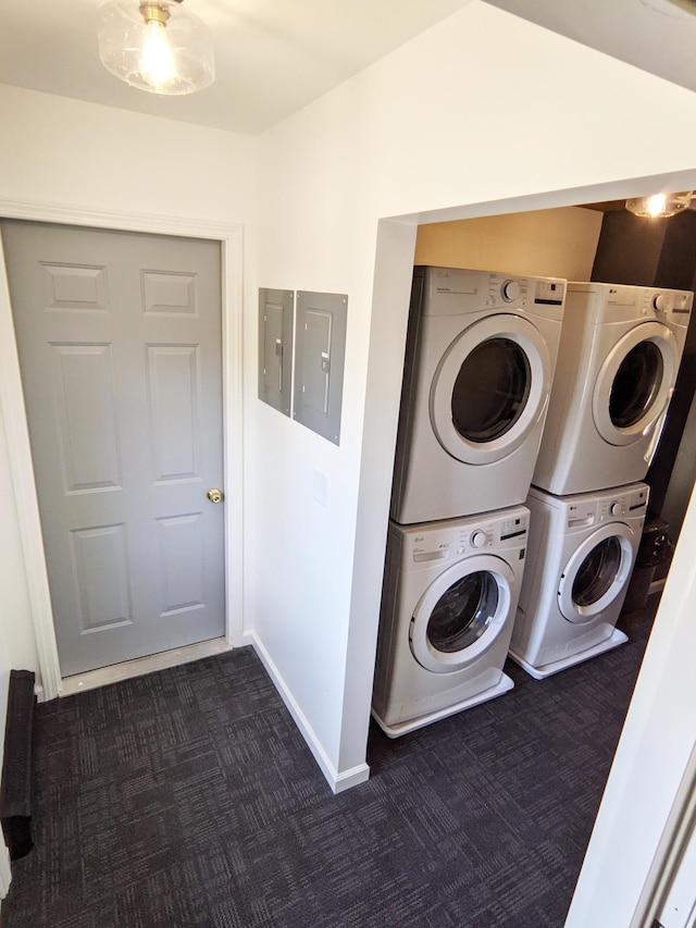 1101 Spring Creek Rd, Northfield, MN 55057 - laundry area with stacked washer / drying machine, dark colored carpet, electric panel, and baseboards