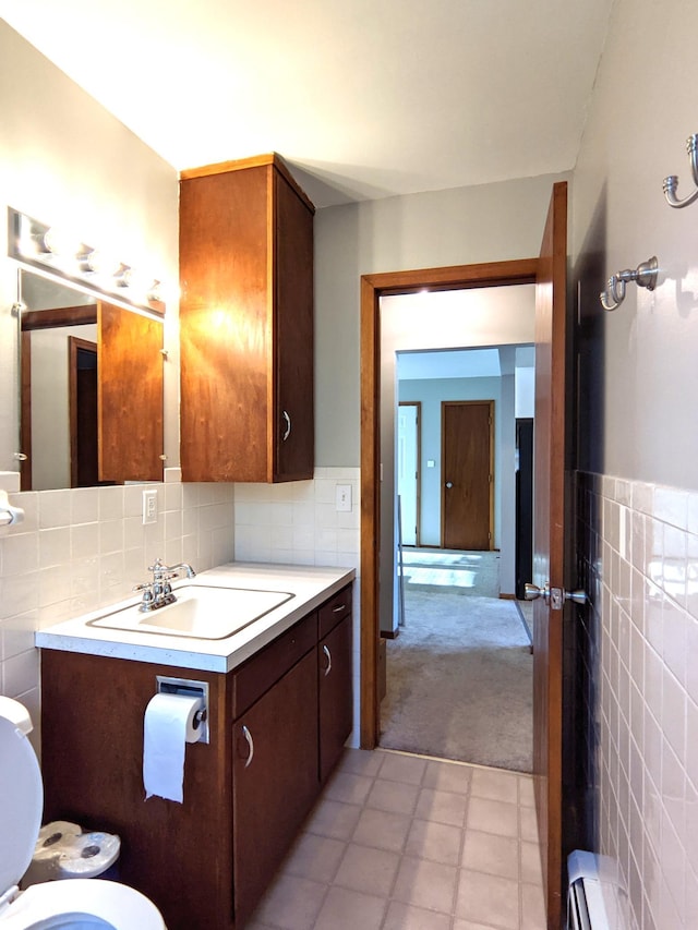 1101 Spring Creek Rd, Northfield, MN 55057 - half bath featuring tile walls, toilet, vanity, tile patterned floors, and a baseboard heating unit