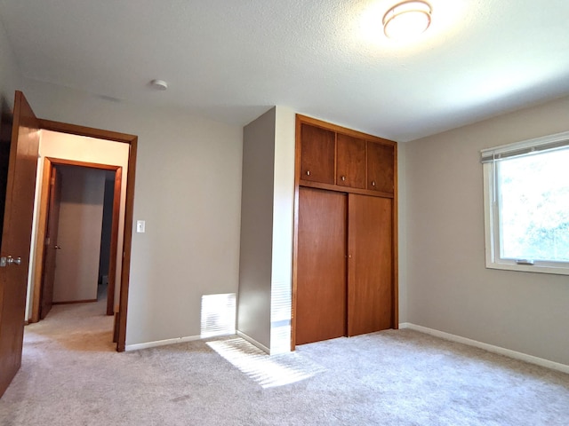 1101 Spring Creek Rd, Northfield, MN 55057 - unfurnished bedroom with a closet, light carpet, baseboards, and a textured ceiling