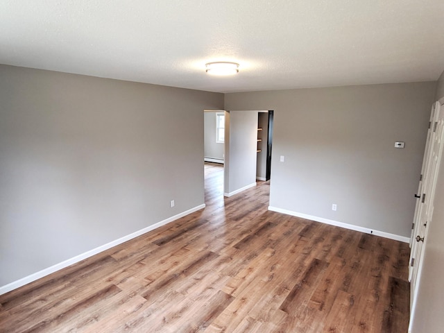 1101 Spring Creek Rd, Northfield, MN 55057 - unfurnished room with baseboard heating, wood finished floors, and baseboards