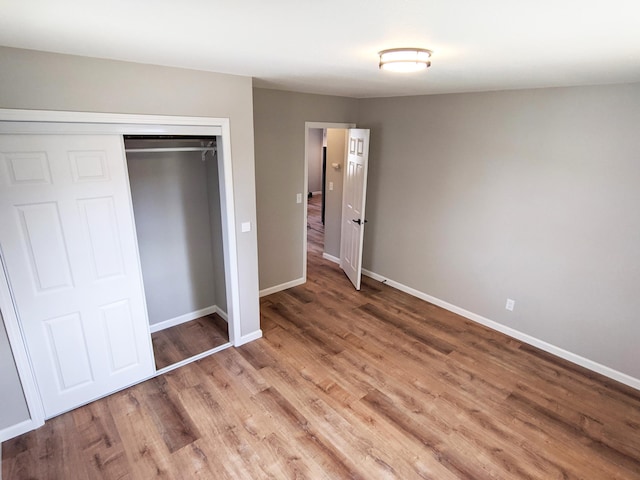 1101 Spring Creek Rd, Northfield, MN 55057 - unfurnished bedroom with wood finished floors, baseboards, and a closet