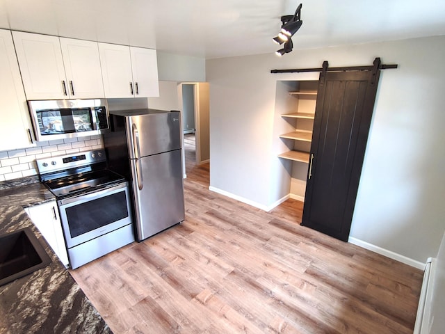 1101 Spring Creek Rd, Northfield, MN 55057 - kitchen featuring stainless steel appliances, baseboards, light wood-style flooring, and white cabinets