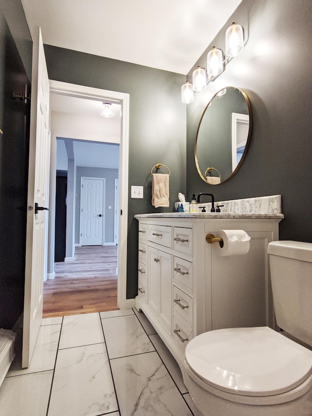 1101 Spring Creek Rd, Northfield, MN 55057 - bathroom with toilet, vanity, marble finish flooring, and baseboards