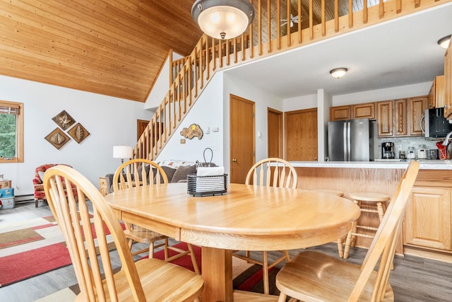 13771 Schuelke Beach Rd NW, Leaf Valley Twp, MN 56354 - dining room featuring lofted ceiling, stairway, light wood-type flooring, baseboard heating, and wooden ceiling